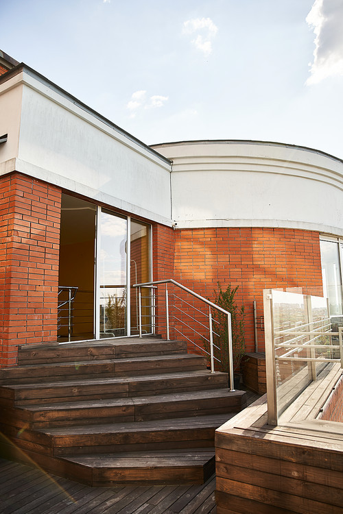 A brick building standing tall, adorned with a sleek metal handrail adding a modern touch to the old world charm