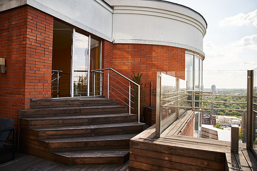 A balcony with a stunning view of the city skyline, showcasing skyscrapers, busy streets, and a bustling metropolis below