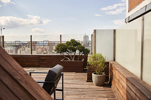 A wooden deck adorned with a chair and potted plants, creating a tranquil and peaceful outdoor space