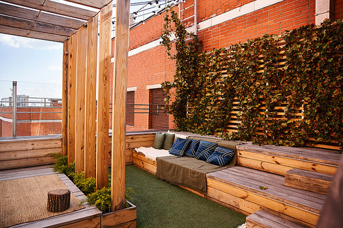 A stylish couch sits elevated on top of a sturdy wooden bench, creating a unique and striking furniture arrangement