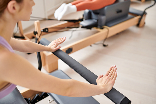 A sporty woman engages in a pilates lesson in the gym.