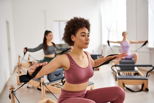 Group of sporty women practicing pilates in a studio.