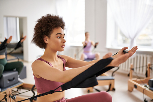 A group of pretty sporty women in a gym doing exercises during a pilates lesson.