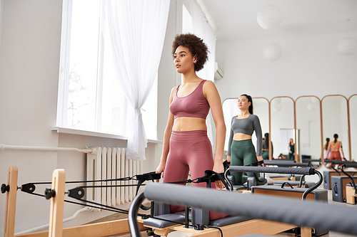 A group of pretty sporty women exercising with various gym equipment during a pilates lesson.