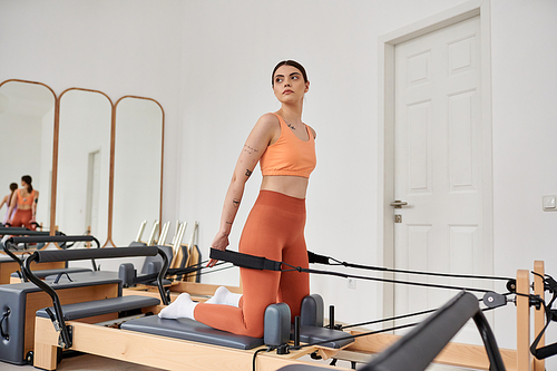 Pretty woman in comfy sportswear practising during pilates lesson.