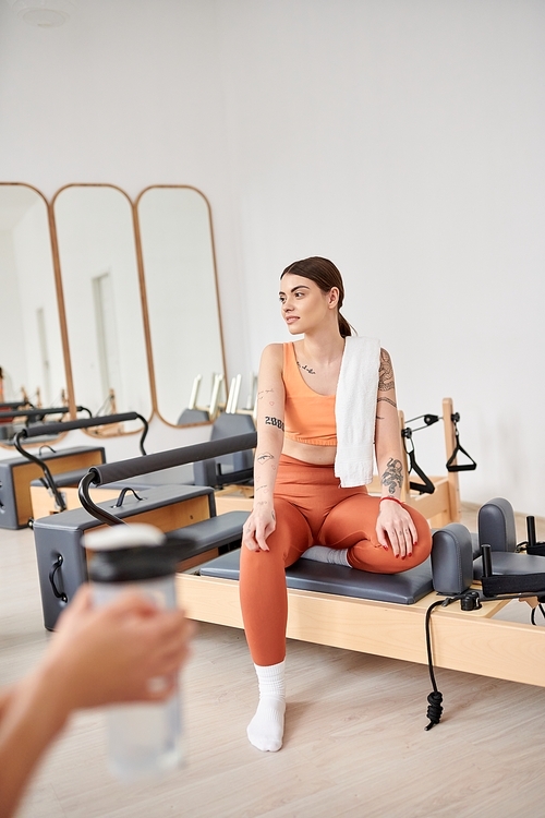 Athletic women spending time together on pilates lesson in gym, relaxing.