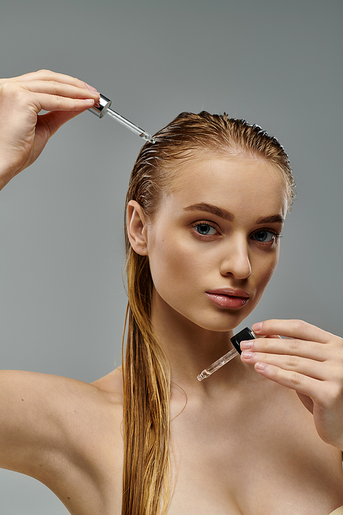 Young, beautiful woman delicately taking care of her hair.