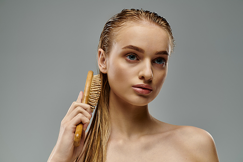 A beautiful young woman demonstrating her hair care routine with a brush in hand.