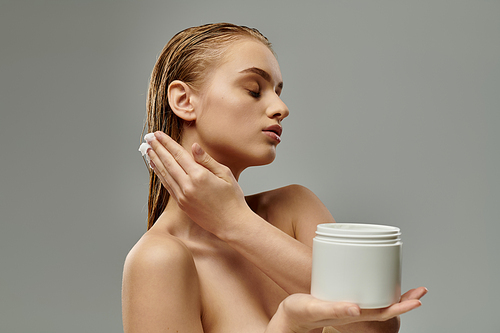 A woman holds a jar of hair mask, part of her hair care routine.