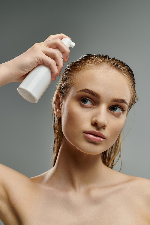 Beautiful woman applying hair treatment.