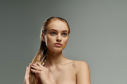 Beautiful woman with long hair tenderly applying hair care products.