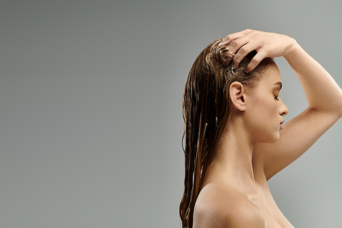 Long-haired beauty unveils her hair care routine against a gray backdrop.