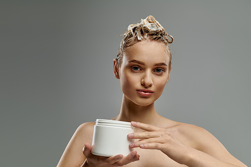 Attractive woman holding a jar of hair mask.