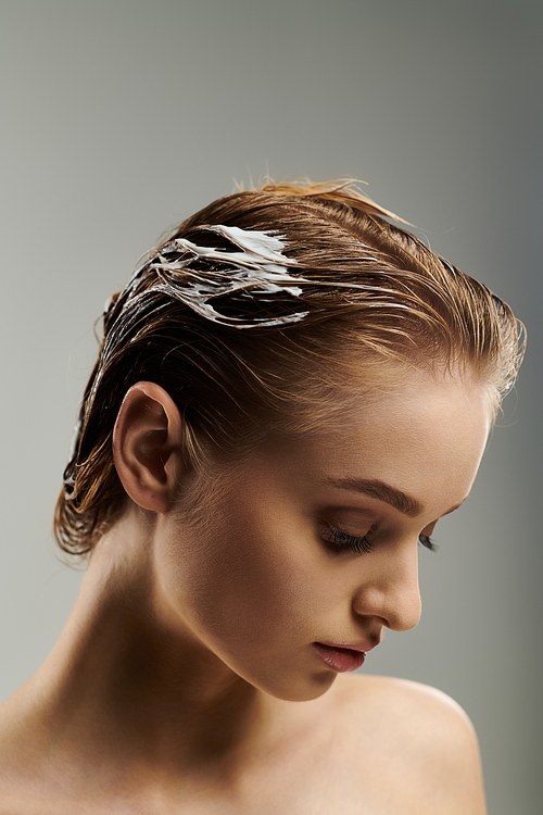 Young beautiful woman demonstrating hair care routine with wet hair.