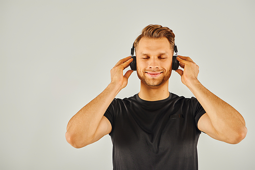 A man immersed in his own world, listening to music through headphones.