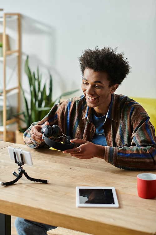 A young African American man busy with his tablet and phone, multitasking as a content creator.