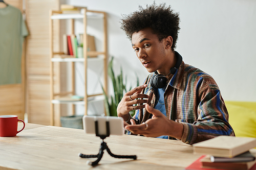 A young man sits at a table, speaking confidently.