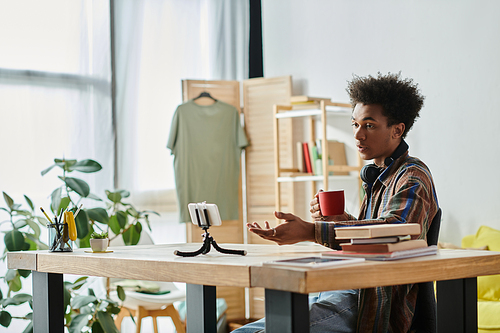 A man with a phone and coffee at a table.