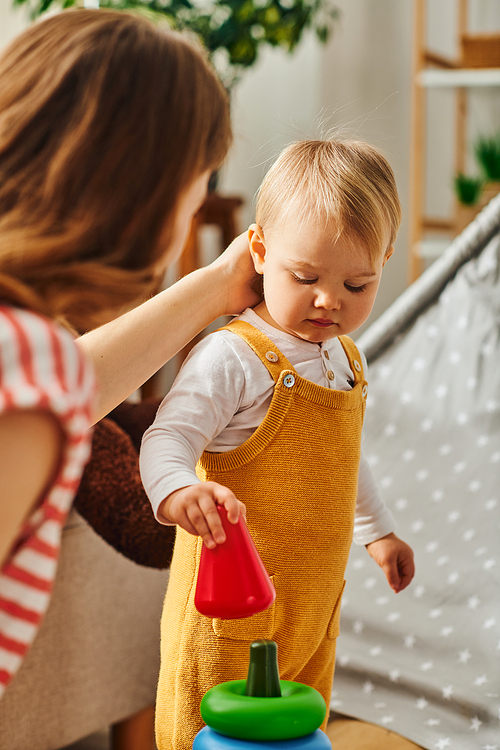 A young mother gently touching her toddler daughter enjoy precious time together.