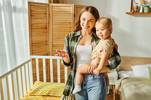 happy young mother lovingly cradles her toddler daughter in her arms, creating a tender moment of connection and affection at home.