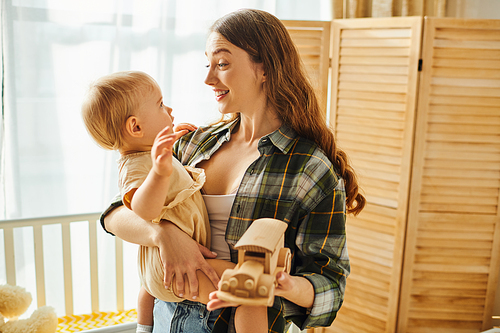 A young mother holding her toddler daughter tenderly in her arms, sharing a special moment filled with love and affection.