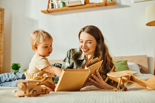 A young mother and her toddler daughter happily playing with vibrant wooden toy, and reading book creating a heartwarming scene of joy and bonding.