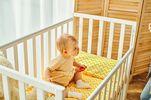 toddler baby girl in a crib, sharing a precious moment of coziness at home.