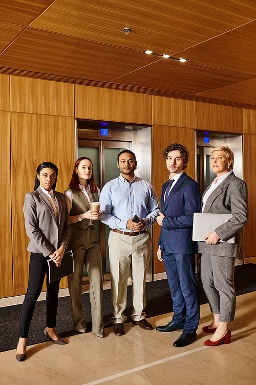 Diverse business professionals discussing ideas in elevator.