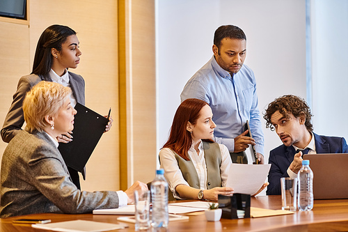 Diverse group of business professionals collaborating at conference table.