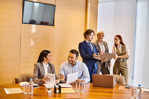 Multicultural group of business professionals engaged in a meeting at a conference table.