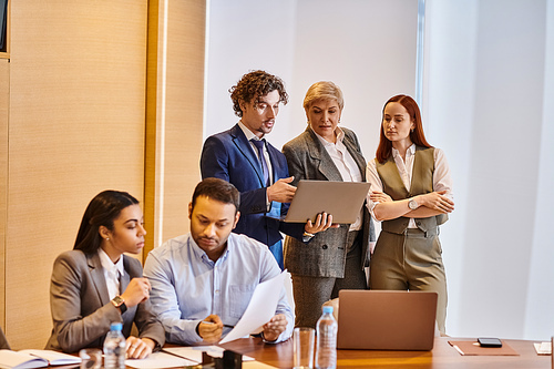 Diverse business team discussing strategy at conference table.