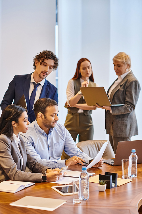 Multiracial business team collaborating around a conference table.