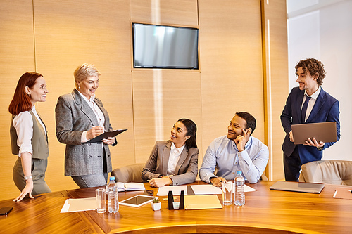 Multicultural business professionals brainstorm and collaborate at conference table.