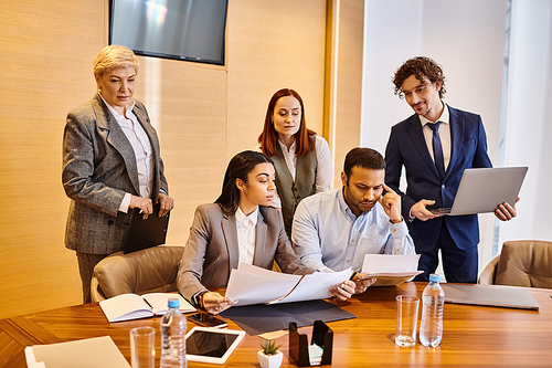 A diverse group of business professionals discussing ideas around a conference table.