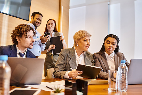 Diverse group of business professionals brainstorming around laptops at a table.