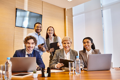 Diverse business team using laptops at table.