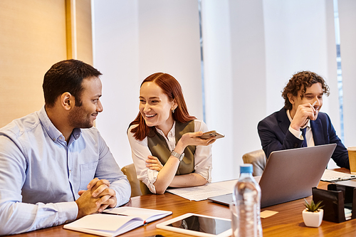 Diverse group of business professionals deep in discussion around a wooden table.