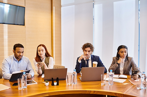 Diverse group of professionals collaborate around conference table.