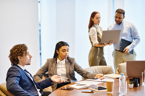 Multicultural business professionals collaborate at a conference table.