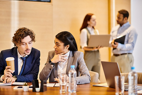 A diverse group of professionals are discussing and collaborating around a conference table.