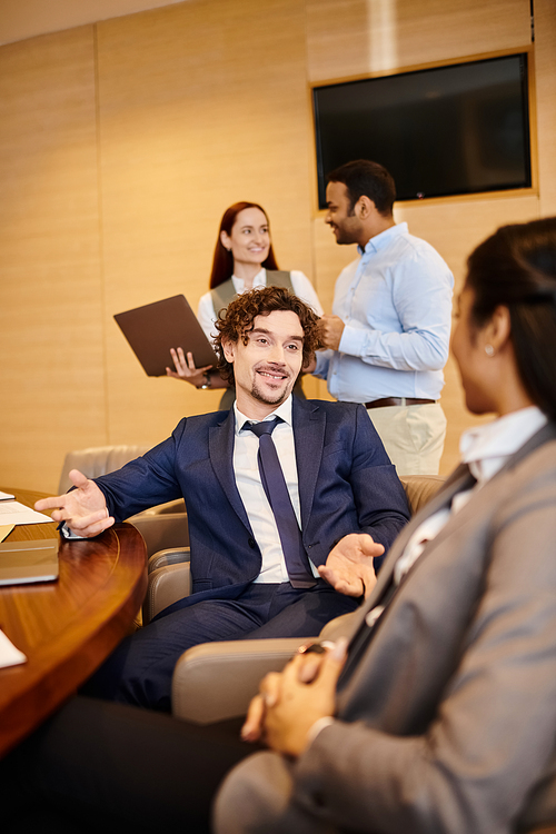 Multicultural business professionals engaged in discussion at a conference table.