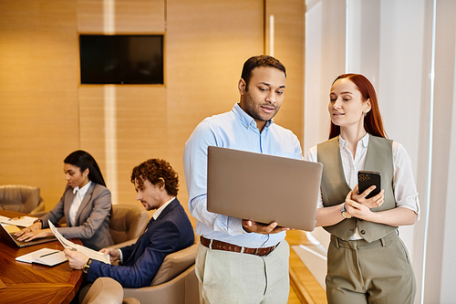 Diverse business team using laptops at a table.