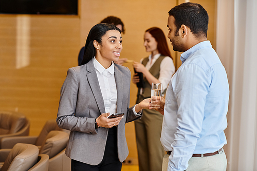 A woman in a business suit conversing with a man in a suit.