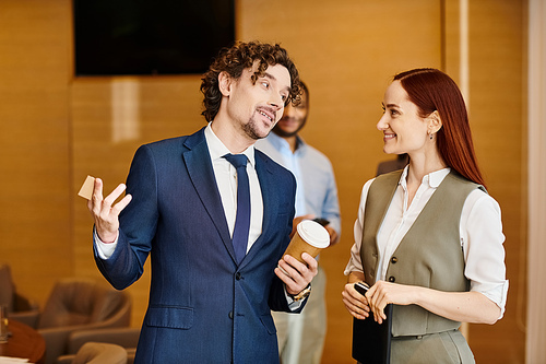 An interracial man in a suit stands next to a woman, collaborating.