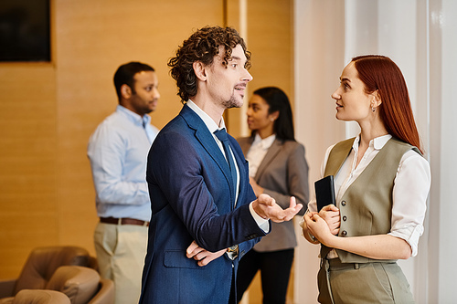 A man and woman in suits engaged in conversation.