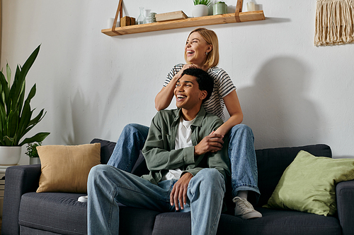 A young interracial couple relaxes and enjoys each others company in their modern apartment.