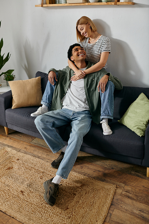 A young multicultural couple enjoys a relaxing afternoon together in their modern apartment.