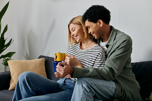 A young interracial couple enjoys coffee and each others company in their modern apartment.