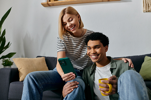 A young multicultural couple relaxes on a couch in a modern apartment, enjoying a cozy evening together.