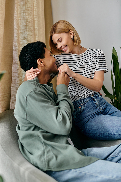 A young multicultural couple shares a joyful moment in their modern apartment, laughing and holding hands.